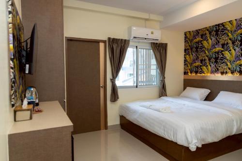 a bedroom with a bed and a window at Sea Inn Pattaya in Pattaya Central