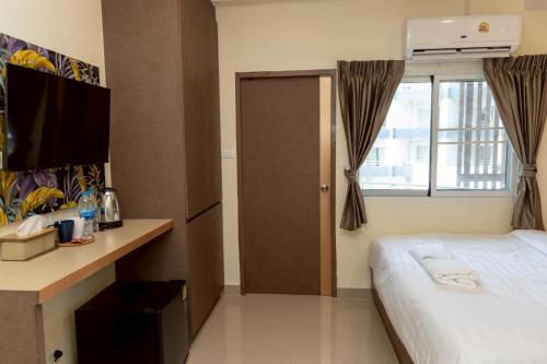 a hotel room with a bed and a window at Sea Inn Pattaya in Pattaya Central