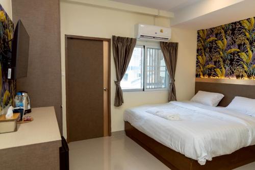 a bedroom with a bed and a window at Sea Inn Pattaya in Pattaya Central