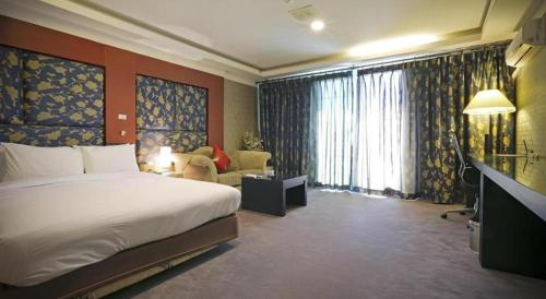 a hotel room with a bed and a living room at Metro Tourist Hotel Cheonan in Cheonan