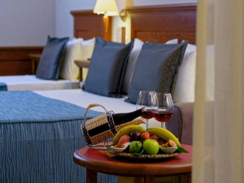a basket of fruit and a glass of wine on a table at Hotel Grand Kaptan - Ultra All Inclusive in Alanya