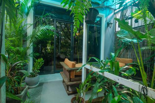 a porch with plants and a chair on it at Koemle Home in Siem Reap