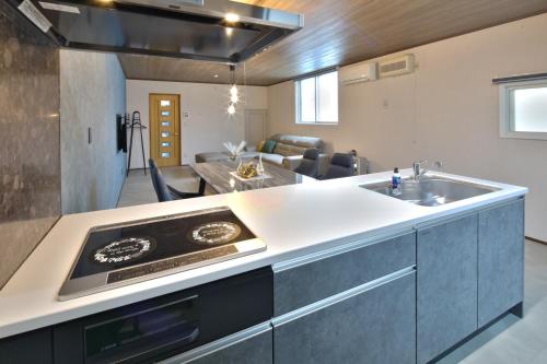 a kitchen with a sink and a living room at GUESTHOUSE LE REPOS - Vacation STAY 18746 in Abashiri