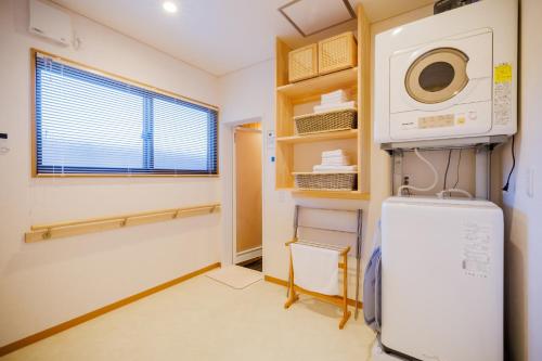 a laundry room with a microwave and a refrigerator at Orihimekan - Vacation STAY 70154v in To-katta