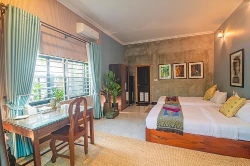 a bedroom with a desk and a bed and a table at Koemle Home in Siem Reap