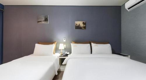 two beds sitting next to each other in a room at BENIKEA Technovalley Hotel in Daejeon