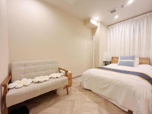 ein Schlafzimmer mit einem Bett und einer Couch in der Unterkunft MIYAVI hotel - Vacation STAY 75579v in Tokio