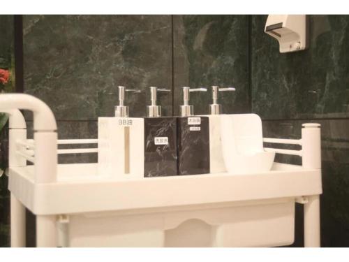 ein weißes Waschbecken mit vier Zahnbürsten drauf in der Unterkunft MIYAVI hotel - Vacation STAY 75579v in Tokio