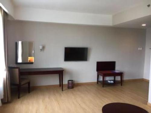 a room with a desk and a television on a wall at Asialink Premier in Karawang