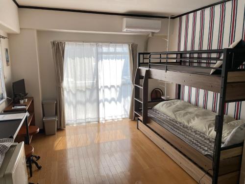 a bedroom with two bunk beds and a window at YS Minami Miyazaki No, 901 - Vacation STAY 18876 in Miyazaki