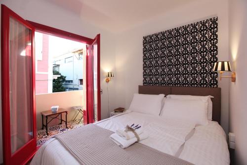 a bedroom with a large white bed with a window at Messini Pension in Nafplio
