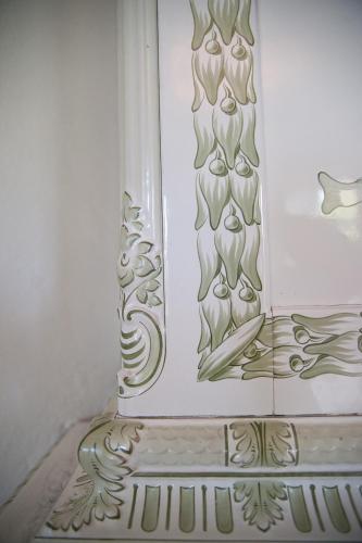 a white vase with a painting on a wall at Hellidens Slott in Tidaholm