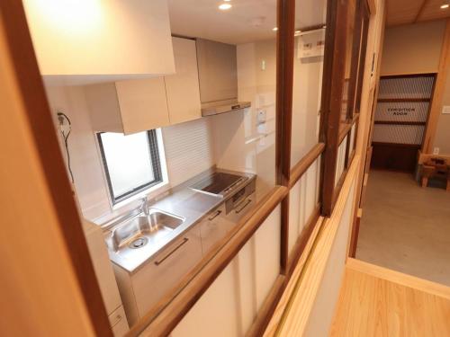 a kitchen with white cabinets and a sink and a window at A-UN INN - Vacation STAY 84863v in Aizuwakamatsu