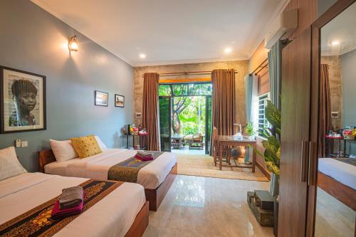 a bedroom with two beds and a living room at Koemle Home in Siem Reap