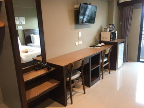 a dressing table with a mirror in a room at Wsotel Hotel in Songkhla