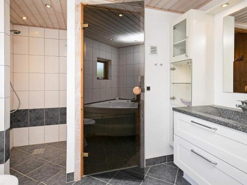 a bathroom with a tub and a sink at 8 person holiday home in Ulfborg in Ulfborg