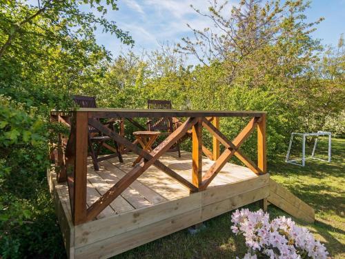 a wooden deck with two benches and a swing at 8 person holiday home in Ulfborg in Ulfborg