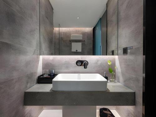 a bathroom with a white sink and a mirror at Aishang Hotel (Lecong Furniture Mall, Foshan) in Shunde