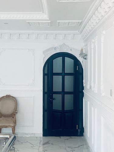 a blue door in a white room with a chair at The Peacock Mansion in Kumasi