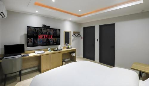 a bedroom with a bed and a tv on the wall at Hotel Primo Daejeon in Daejeon