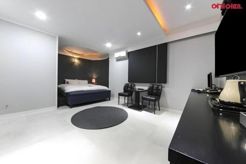 a bedroom with a bed and a table and chairs at Hotel Primo Daejeon in Daejeon