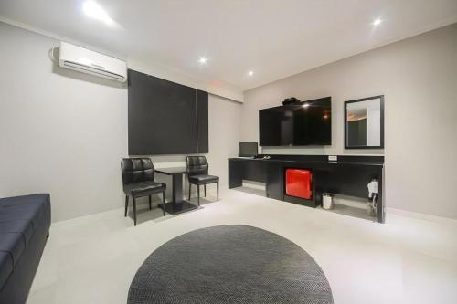 a living room with a couch and a table and a tv at Hotel Primo Daejeon in Daejeon