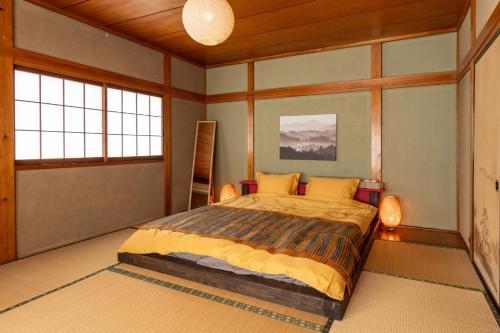 a bedroom with a bed in a room with windows at Refugio del Café - Vacation STAY 92035v in Iwaki