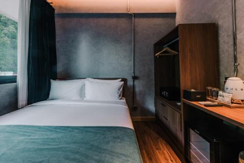 a bedroom with a large bed and a desk at Z Garden Hotel Managed by H Hospitality in El Nido