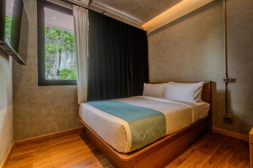 a bedroom with a bed with a window at Z Garden Hotel Managed by H Hospitality in El Nido