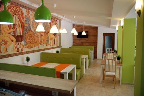 a restaurant with green and green furniture and tables at Green Hisar Hotel Family in Hisarya