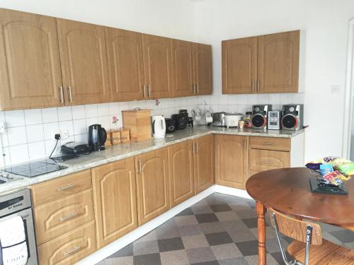 a kitchen with wooden cabinets and a wooden table at South Central Contractors Townhouse in Manchester