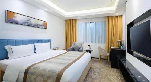 a hotel room with a bed and a flat screen tv at Golden Central Hotel Shenzhen in Shenzhen