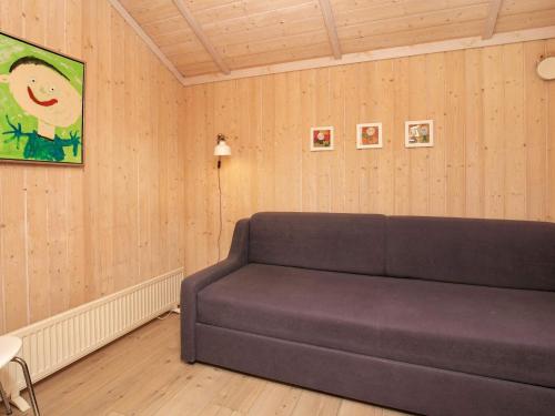 a couch sitting in a room with wooden walls at 4 person holiday home in Vinderup-By Traum in Vinderup