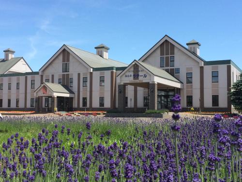 a building with purple flowers in front of it at SPA&HOTEL RESORT Furano La Terre in Nakafurano