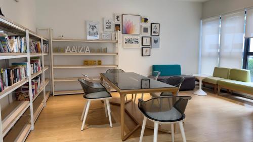 a room with a table and chairs and bookshelves at Danga Bay Coastal Comfort 3BR 8Pax w 3Balcony by Our Stay in Johor Bahru