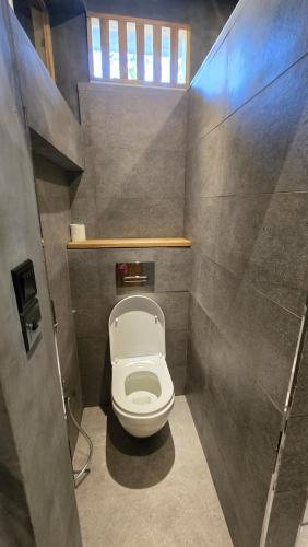 a small bathroom with a toilet in a stall at Bappa's Place in Hiriketiya