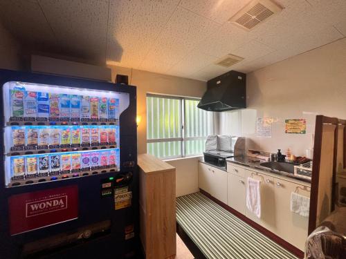 a kitchen with a soda vending machine in a room at 民宿さざんか in Okinawa City