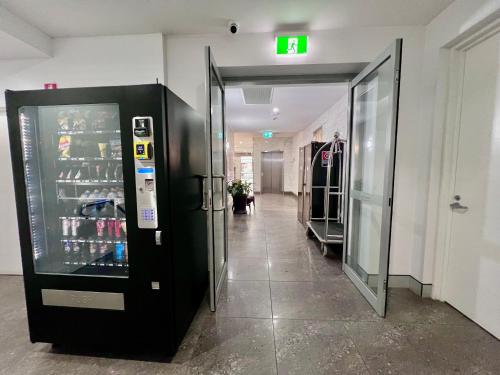 a store aisle with a drink cooler in a store at Crown on Darby Newcastle in Newcastle