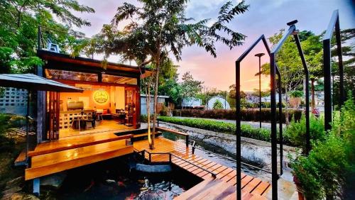 a house with a koi pond in a garden at Heaven Hill Camping in Ban Thung Na