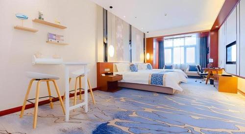 a bedroom with a bed and a desk in it at YUN-RAY Hotel Shijiazhuang in Shijiazhuang