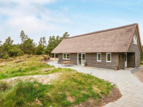a house with a roof on top of a hill at 6 person holiday home in Rømø-By Traum in Toftum