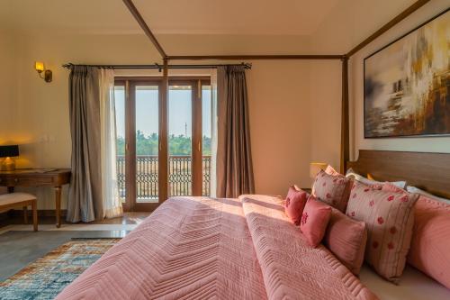 a bedroom with a pink bed with a balcony at Villa Asna, Villas By Noor in Aldona