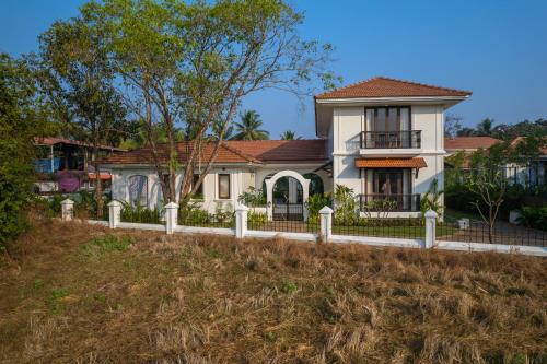 a white house with a fence in front of it at Villa Asna, Villas By Noor in Aldona