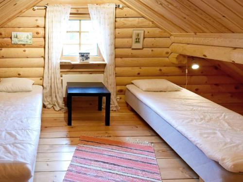 a bedroom with two beds and a desk in a log cabin at 6 person holiday home in SÄLEN-By Traum in Tandådalen