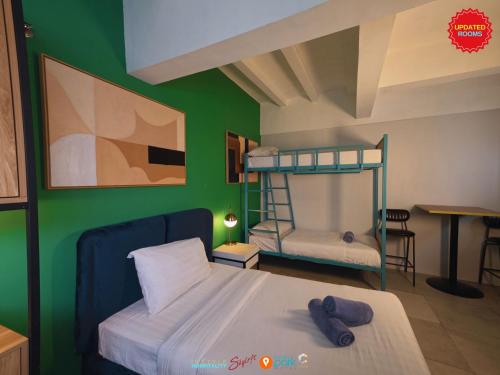 a bedroom with a bunk bed and a green wall at Citizen Hotel in Manila