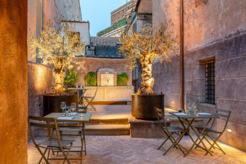 a patio with two tables and trees in a courtyard at Locanda da Enzo in Rome