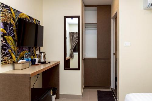 a hotel room with a desk and a mirror at Sea Inn Pattaya in Pattaya Central