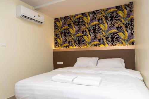 a bedroom with a bed with a painting on the wall at Sea Inn Pattaya in Pattaya Central
