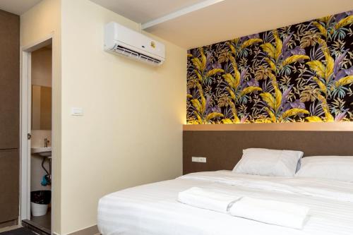 a bedroom with a bed with a painting on the wall at Sea Inn Pattaya in Pattaya Central