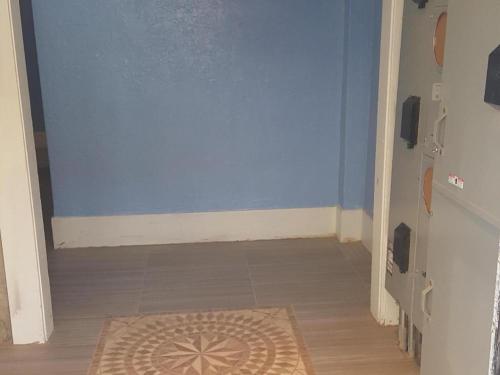 a hallway with a blue wall and a rug on the floor at Desmond Hotel in San Francisco